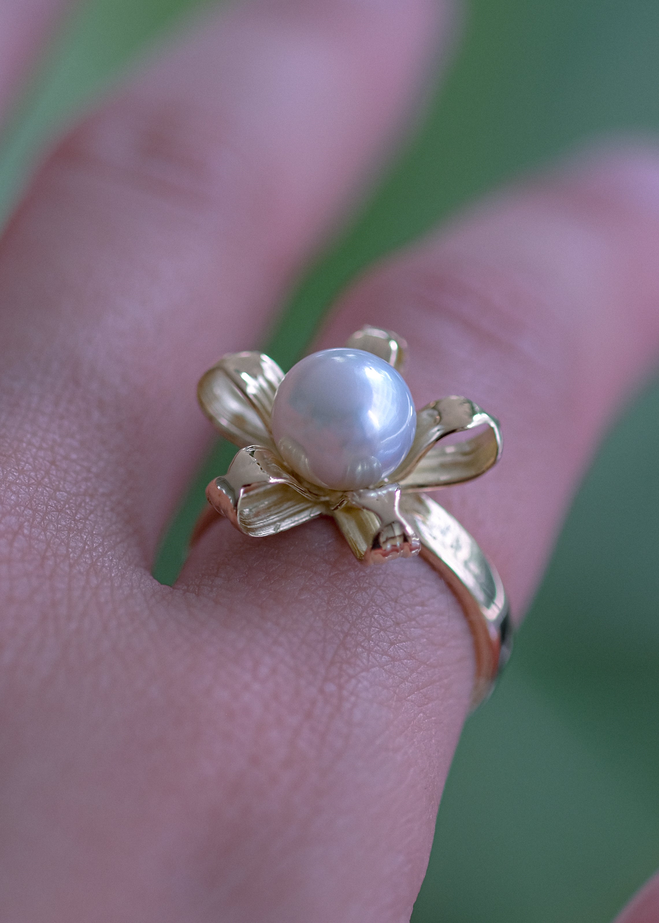 Bold flower ring with a pearl wrapped by 18 karat golden petals