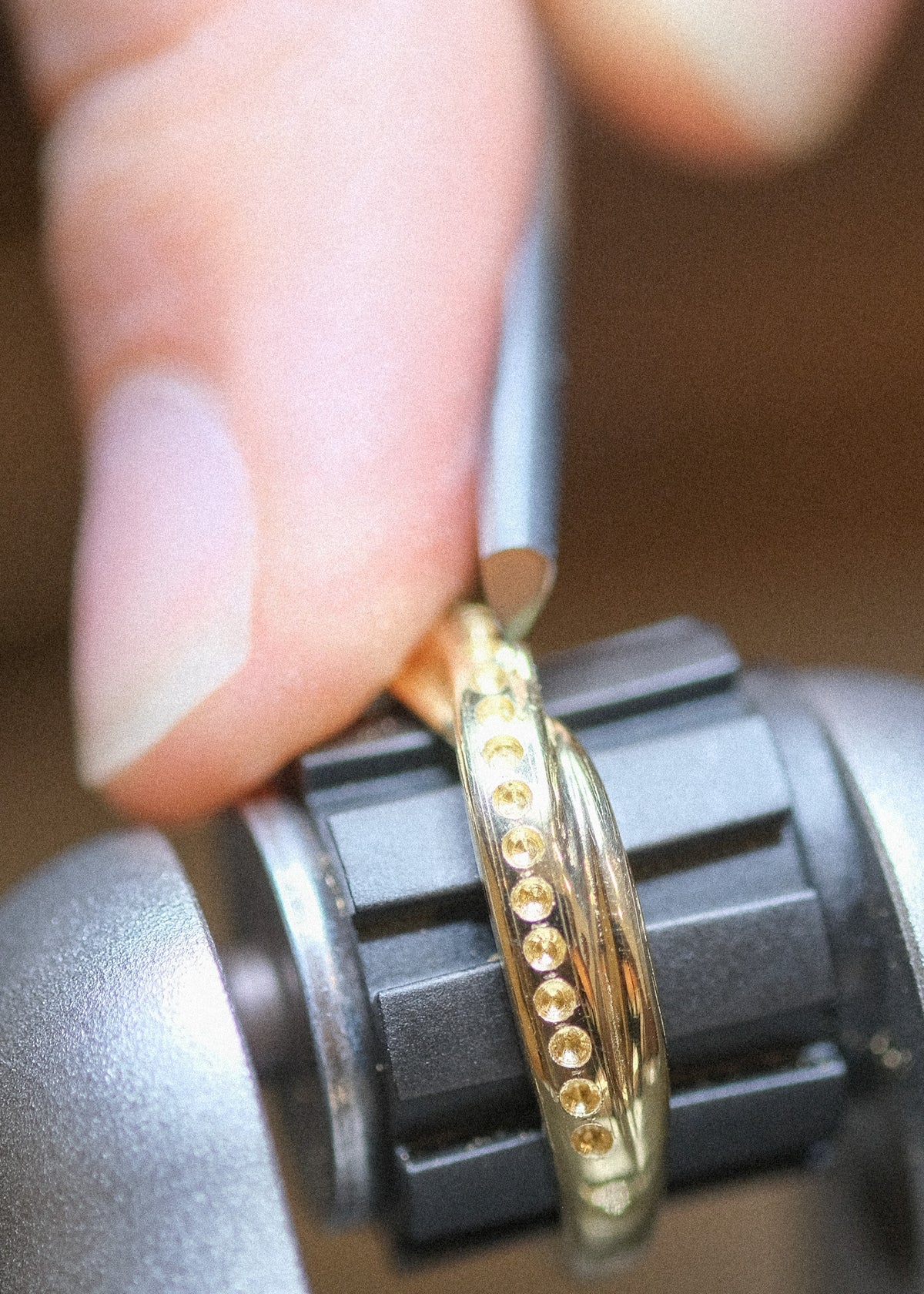 A close-up of Anne Hara setting a row of diamond pave.