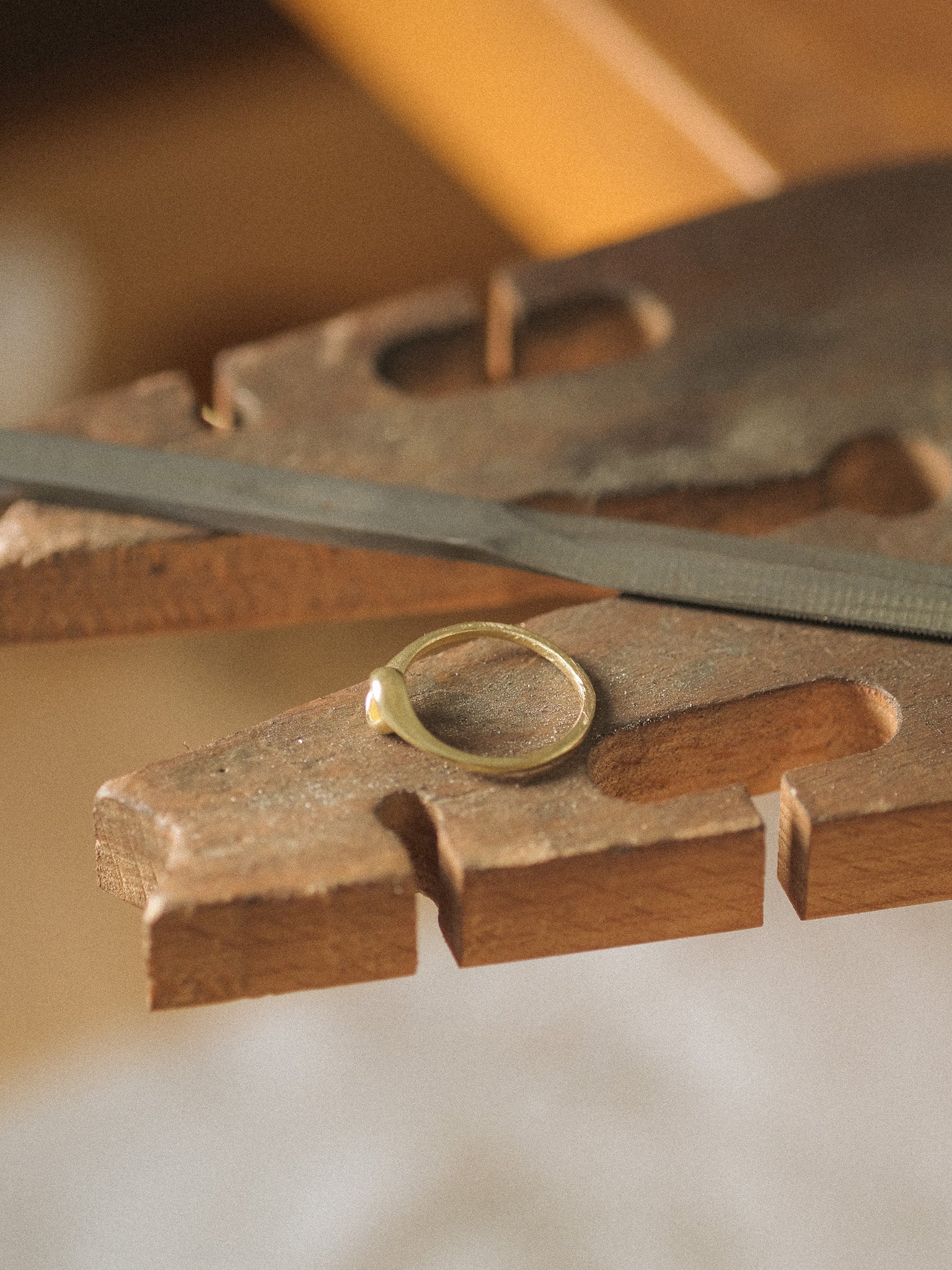 Gold ring on a jeweler's bench peg