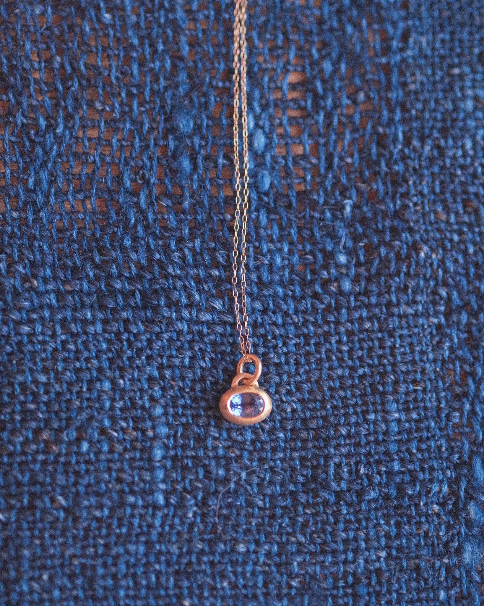 Handcrafted 18k gold pendant featuring a natural blue sapphire by Anne Hara