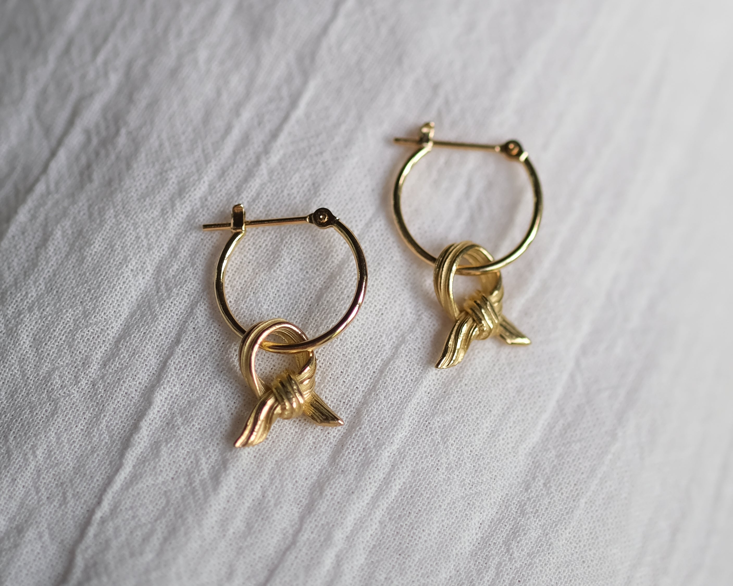 Delicate Gold Knot Charm Earrings On Hoops