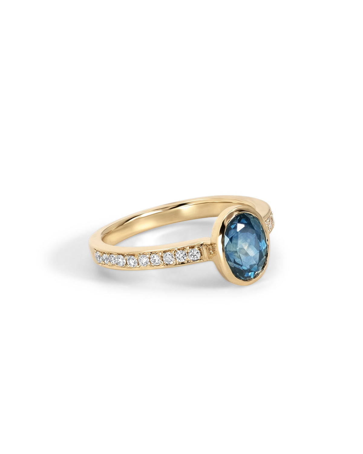One-of-a-kind engagement ring with a 1.51ct oval Montana sapphire, bezel set in 18k gold with bright-cut pave.