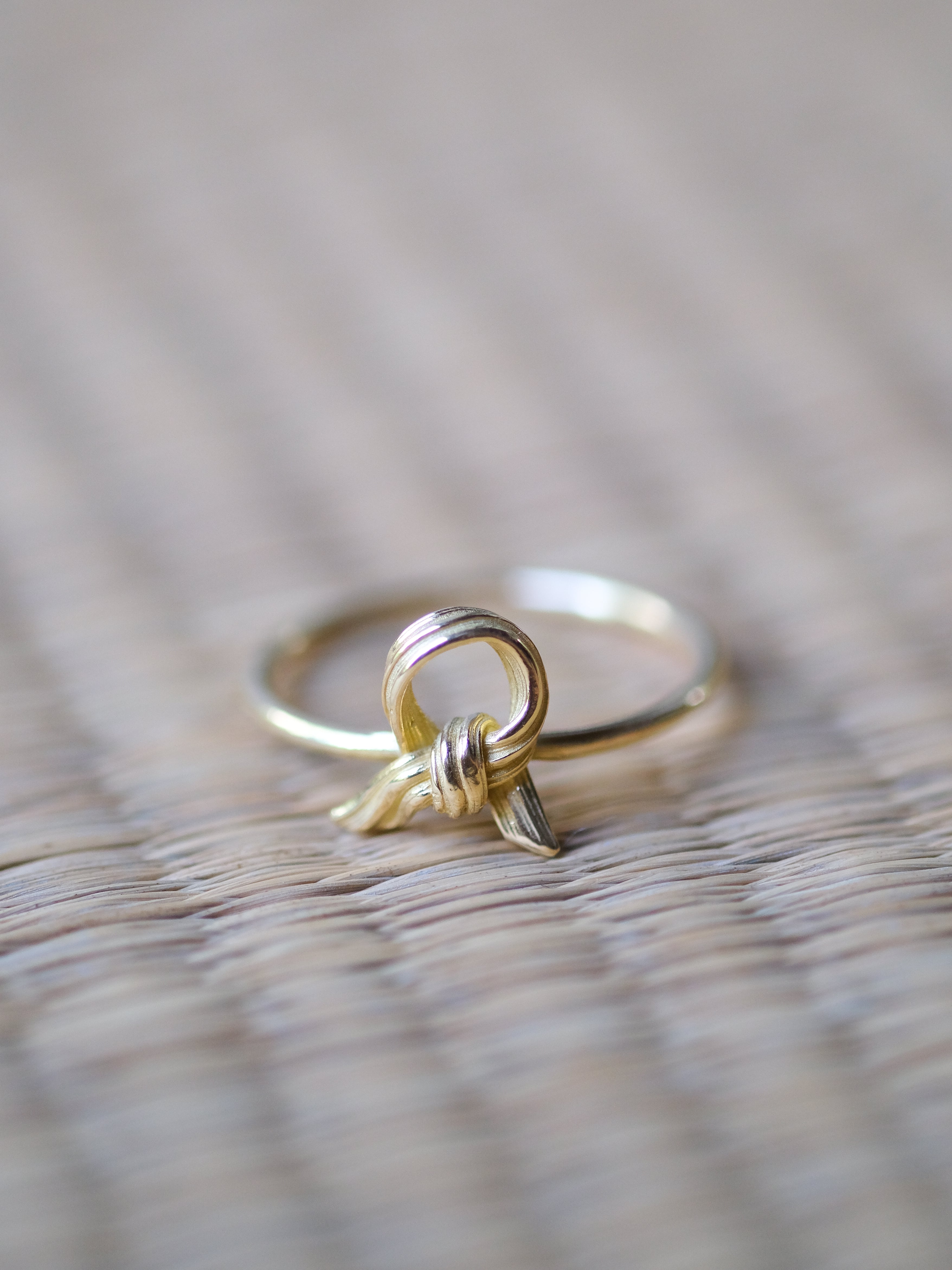 Gold ring with a textured band on a wooden surface